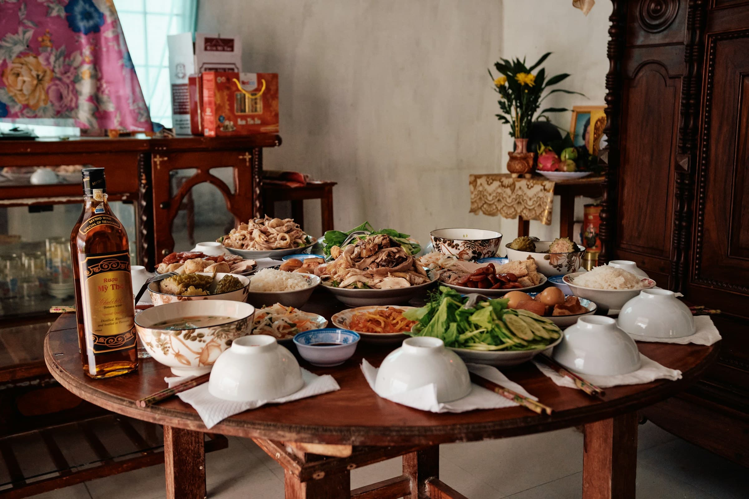 A lavish spread of home-cooked family dishes laid out on a wooden dining table, ready to share